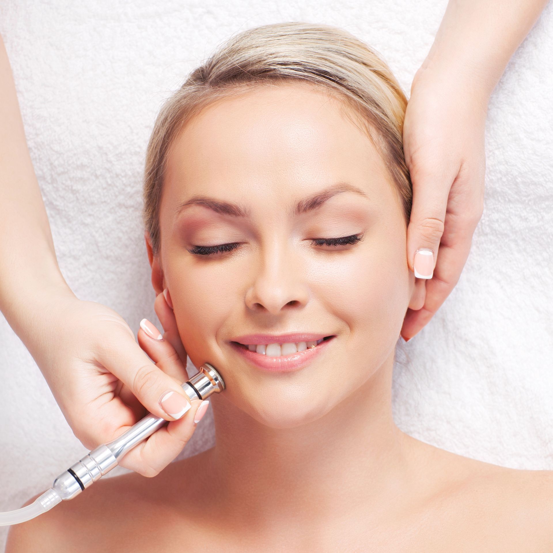 a woman getting a facial treatment with her eyes closed