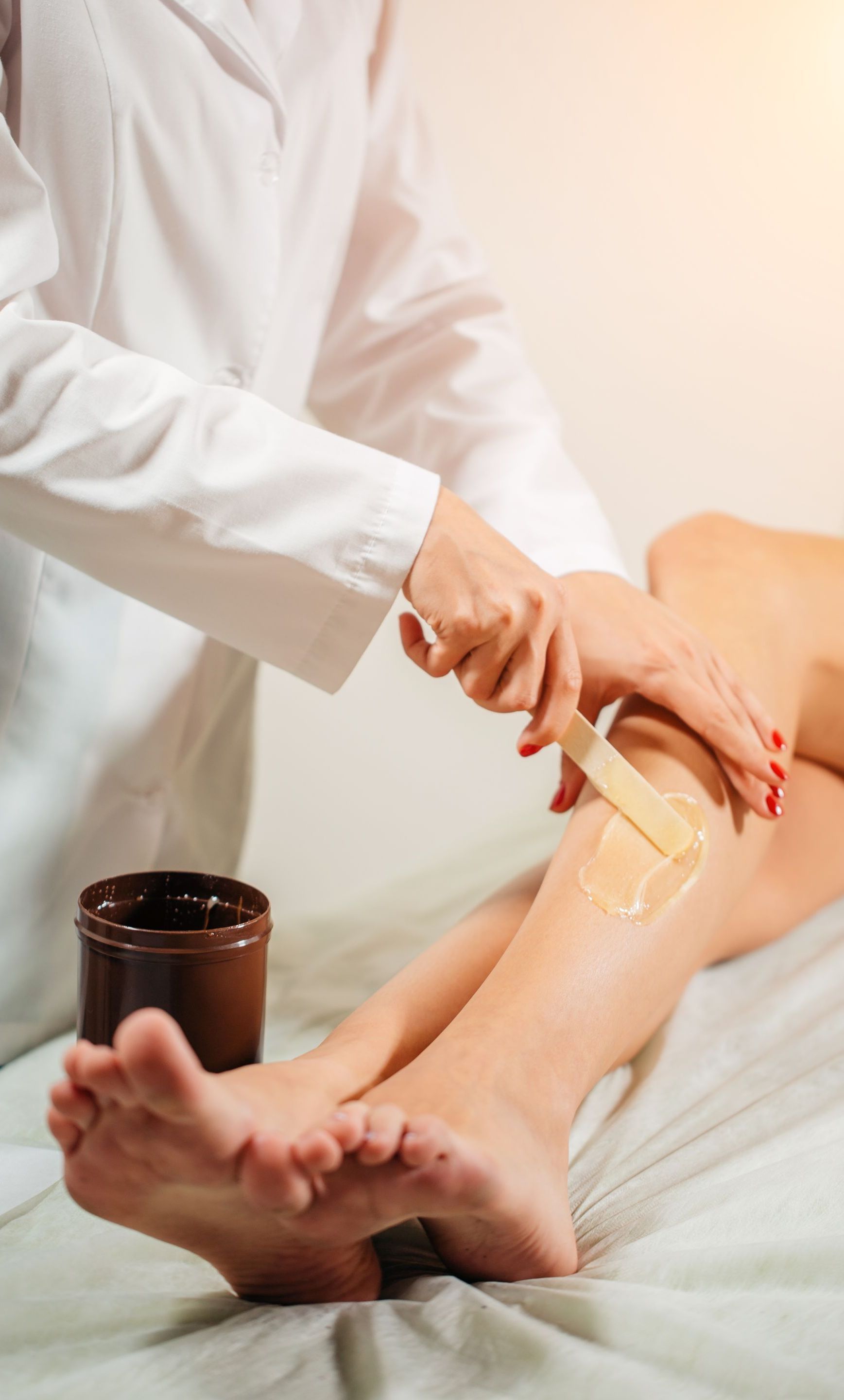 a woman is waxing her leg with a spatula