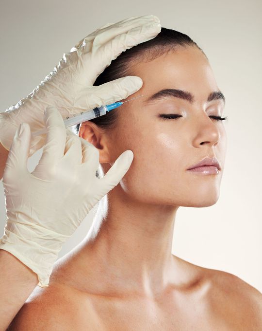 a woman is getting a botox injection in her forehead
