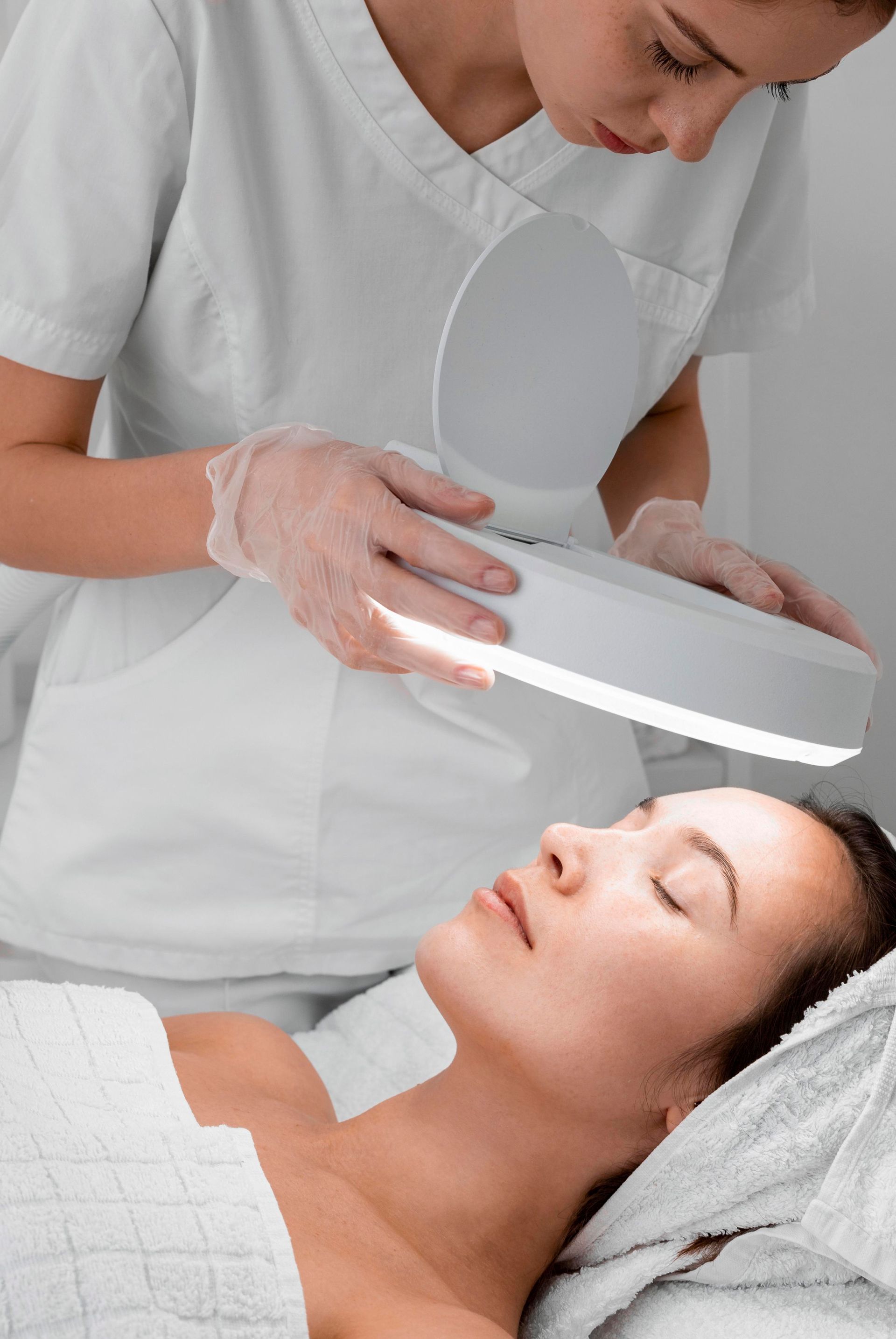 a woman is getting her face examined by a nurse