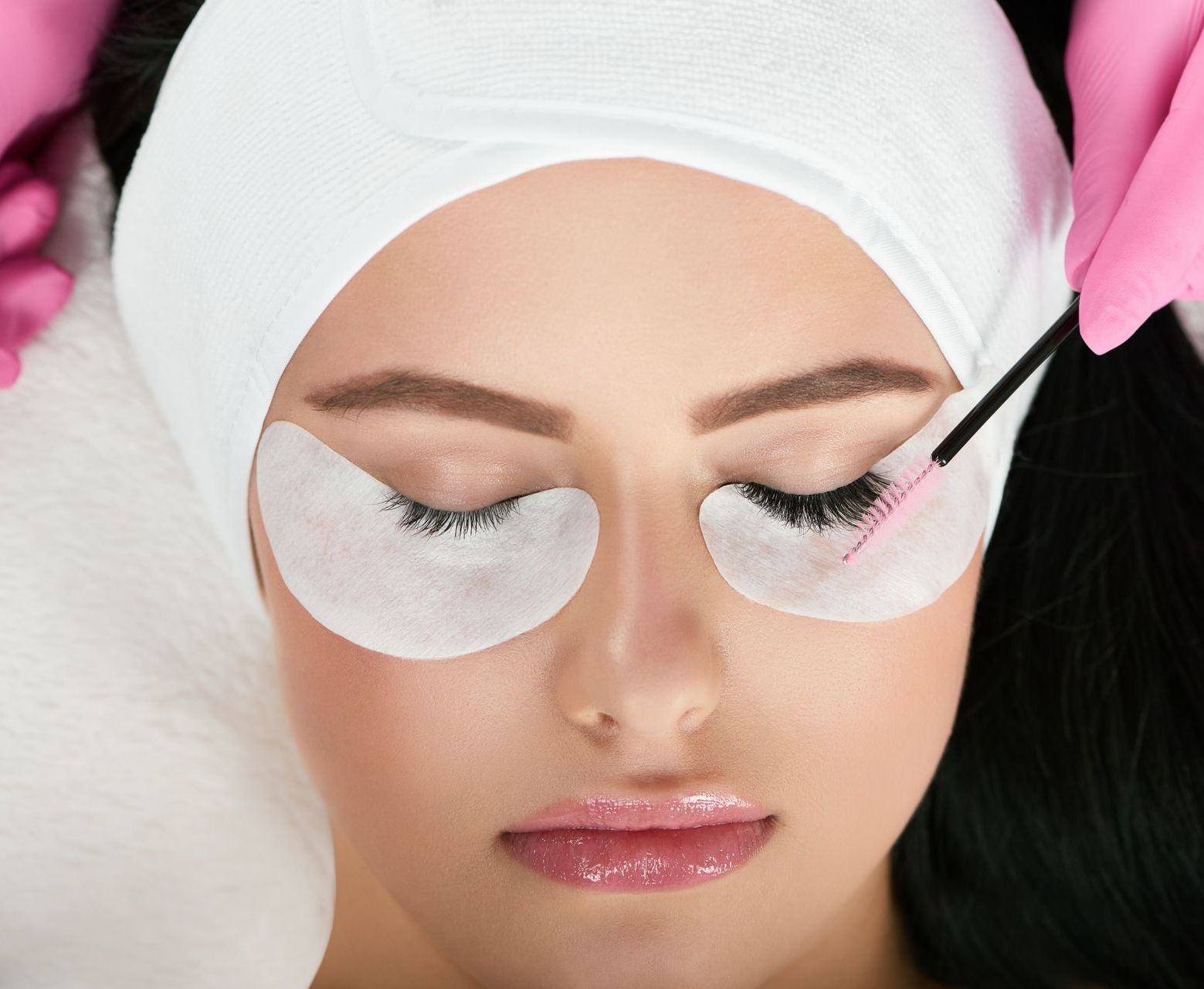 a woman is getting her eyelashes done with a brush