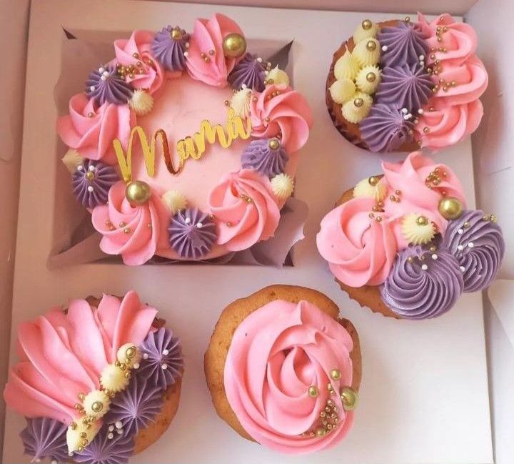 Una caja de cupcakes y un pastel con la palabra mamá en él.