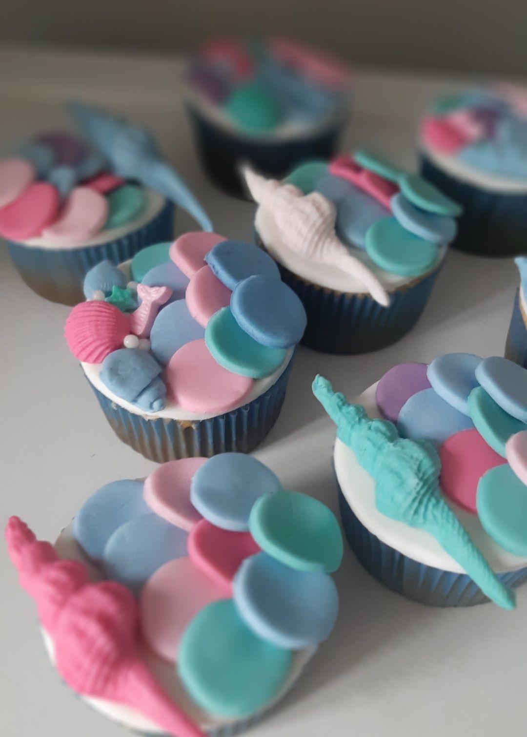 Un montón de cupcakes con glaseado rosa y chispas.