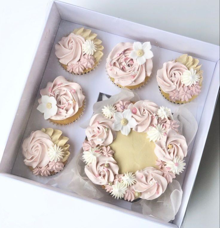 Una caja de cupcakes y un pastel con la palabra mamá en él.