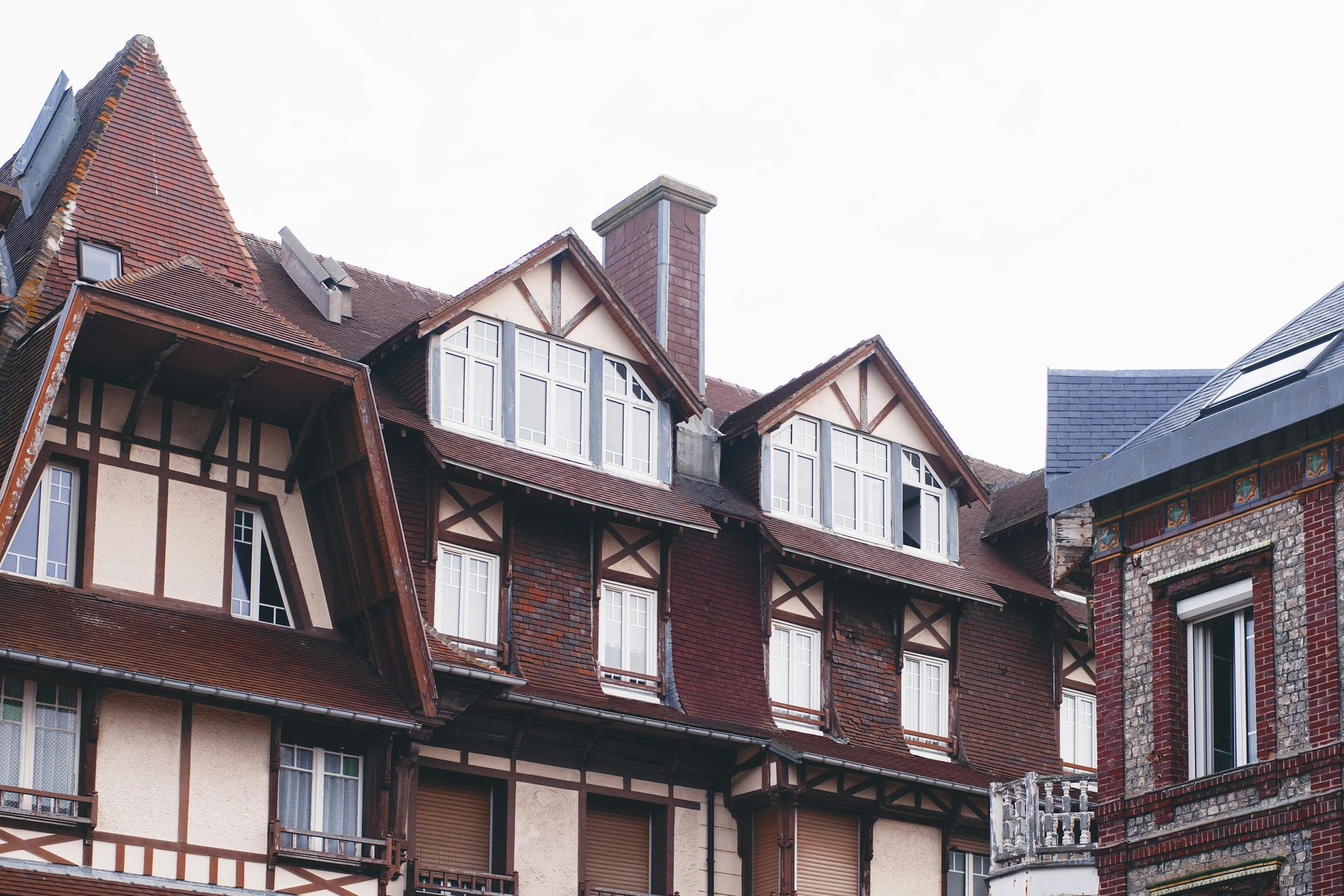 Rangée de maisons à colombages avec toits pentus et lucarnes par temps nuageux