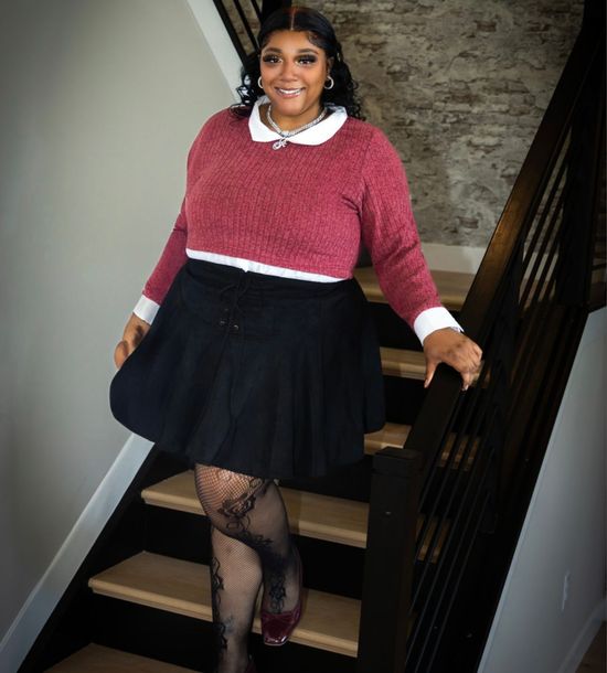 Aniyah Jones, Realtor, is pictured smiling on a staircase in Fischer Homes New Construction community, Calcedonia in Saint Peters, MO.