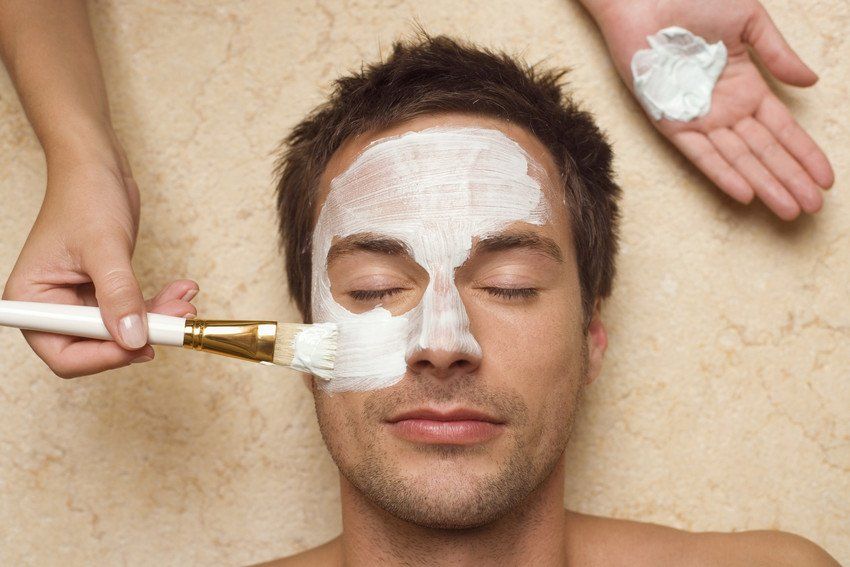 young man having facial pack applied, elevated view
