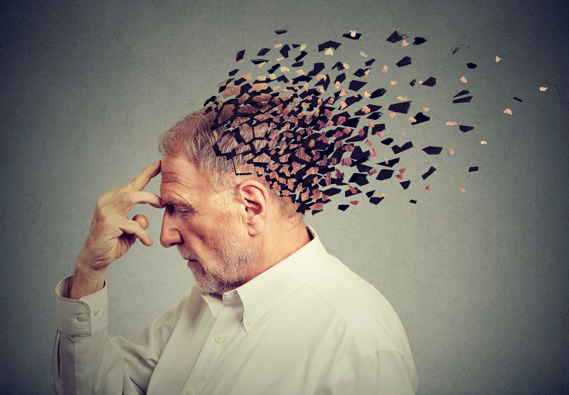A man with a beard is holding his head and his hair is flying out of his head.