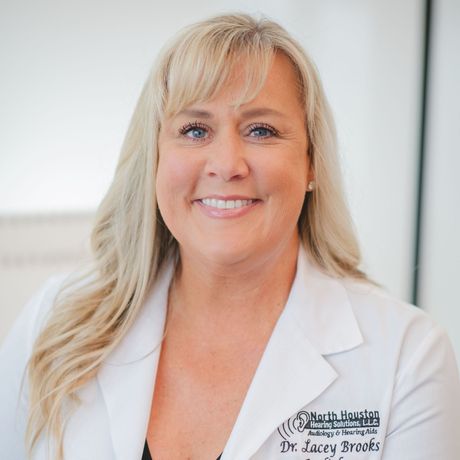 A woman wearing a white lab coat with the name dr. sarah brooks on it