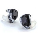 A pair of hearing aids are sitting on a white surface.