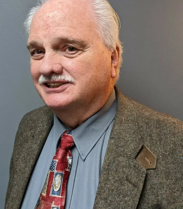 A man in a suit and tie is smiling for the camera