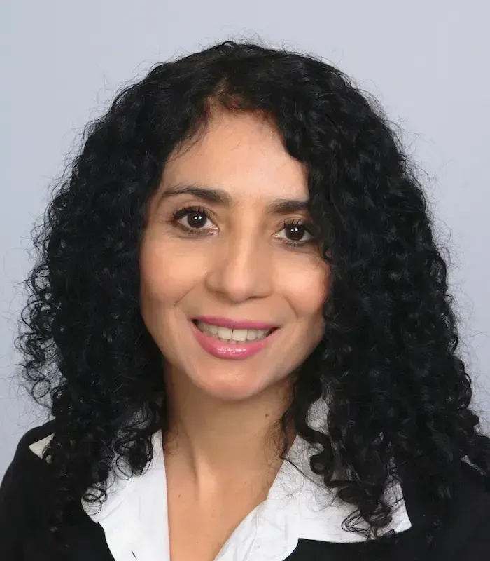 A woman with curly hair is smiling for the camera