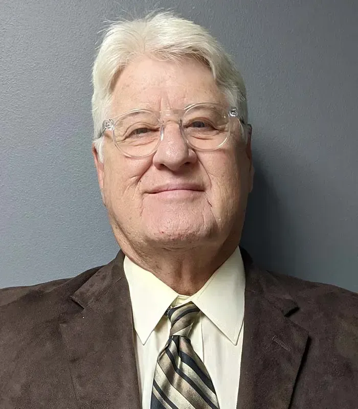 A man in a suit and tie is smiling for the camera.
