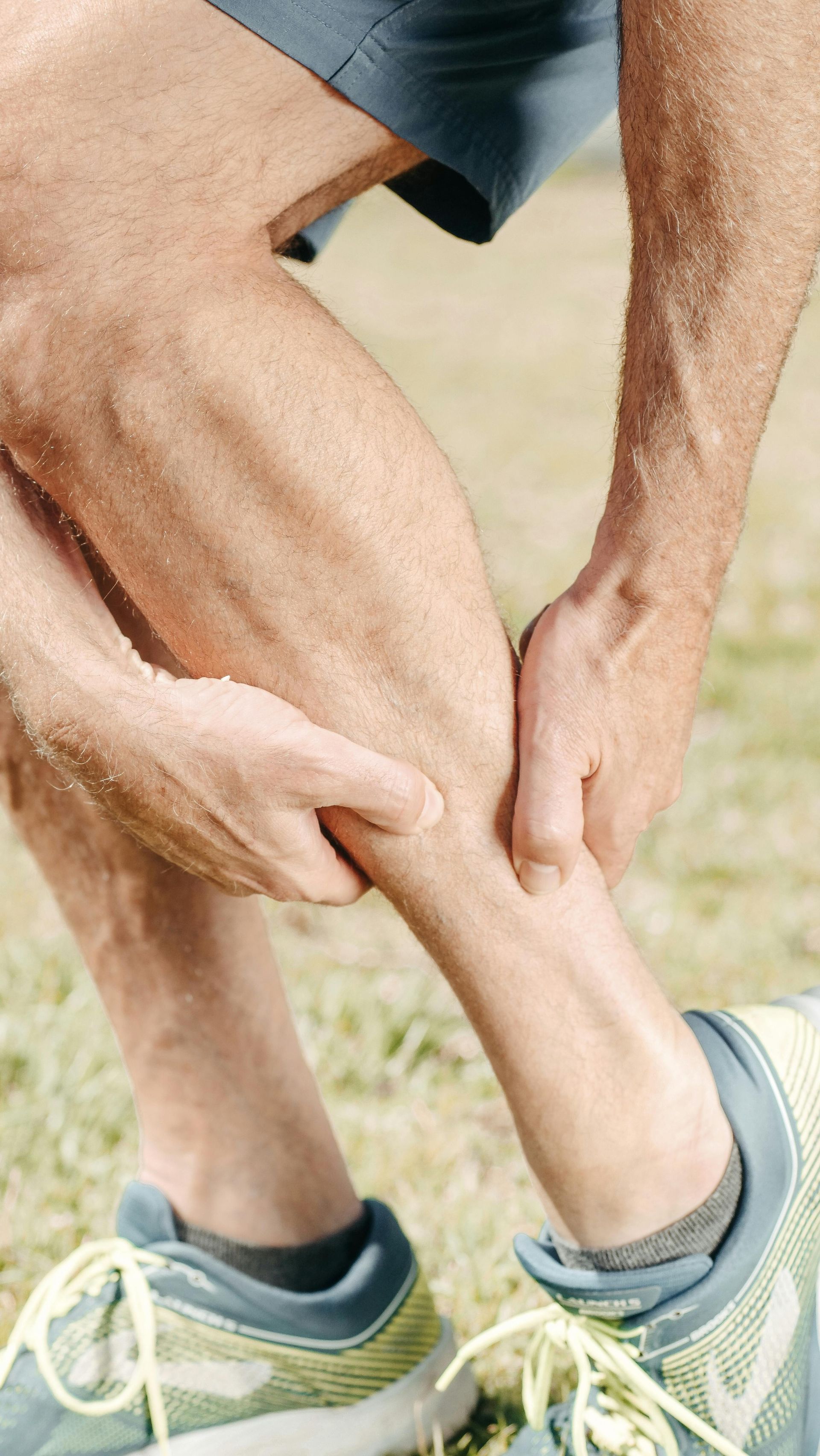 A man is holding his ankle in pain.