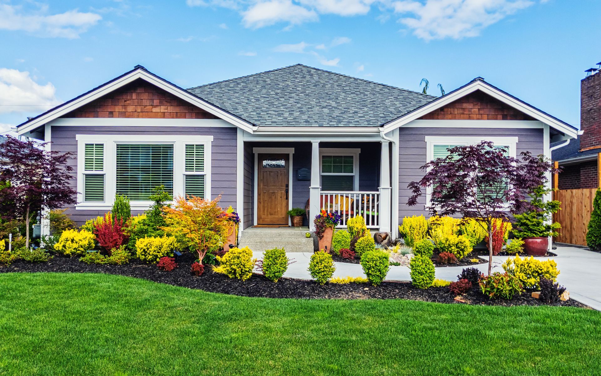 A purple house with a large lawn in front of it.