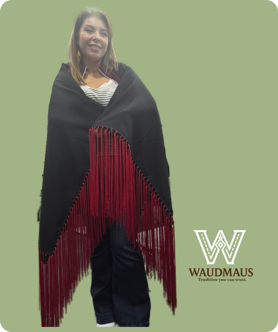 Woman in black shawl with red fringe, smiling. Waudmaus logo.