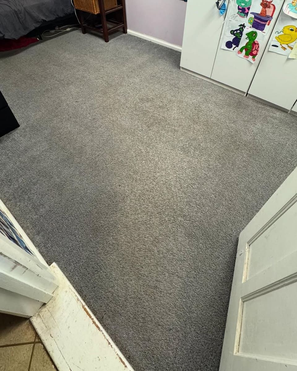 A Bedroom With Grey Carpet, a Wooden Side Table, and White Closet Doors Adorned — Cobra's Carpet Cleaning in Junee, NSW