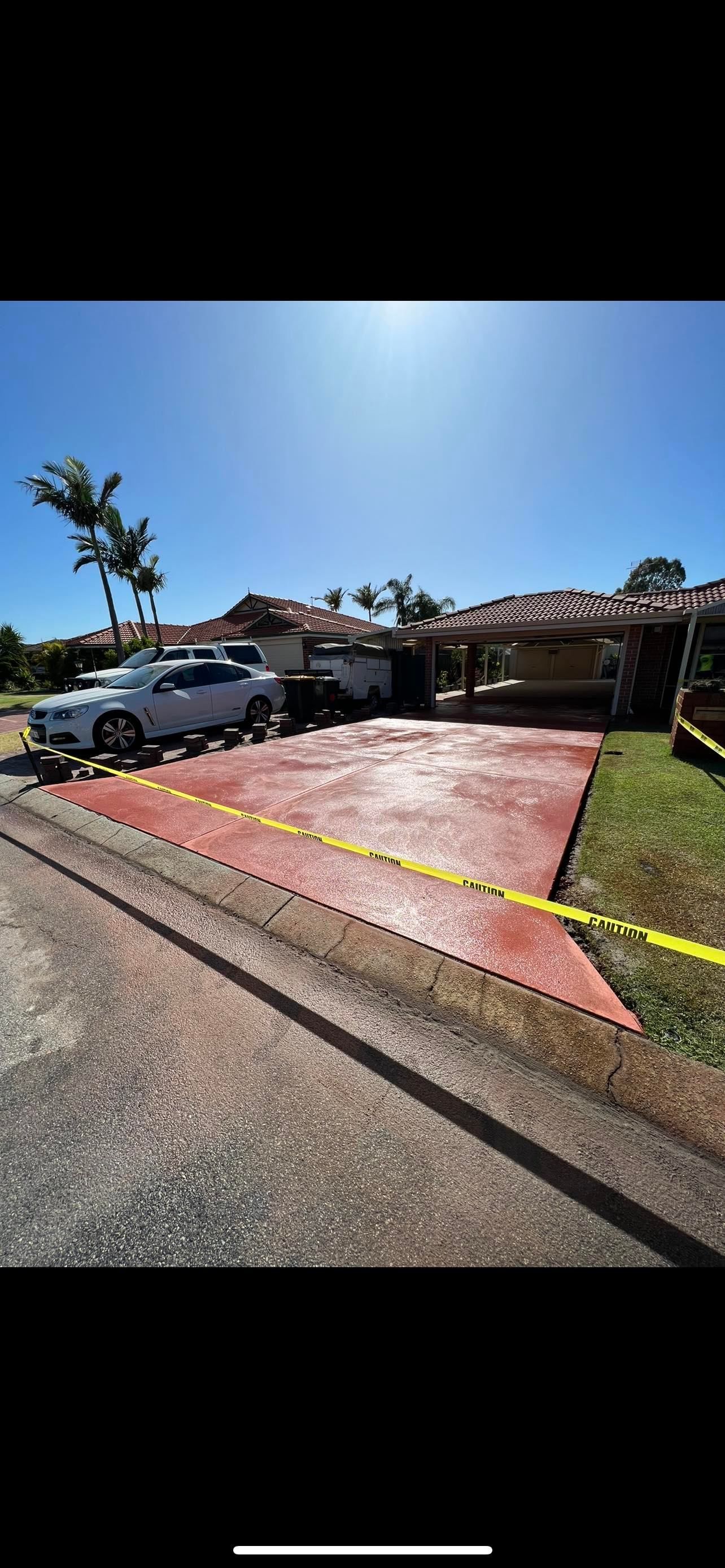 Red coloured concrete driveway for single storey home in Rockingham area