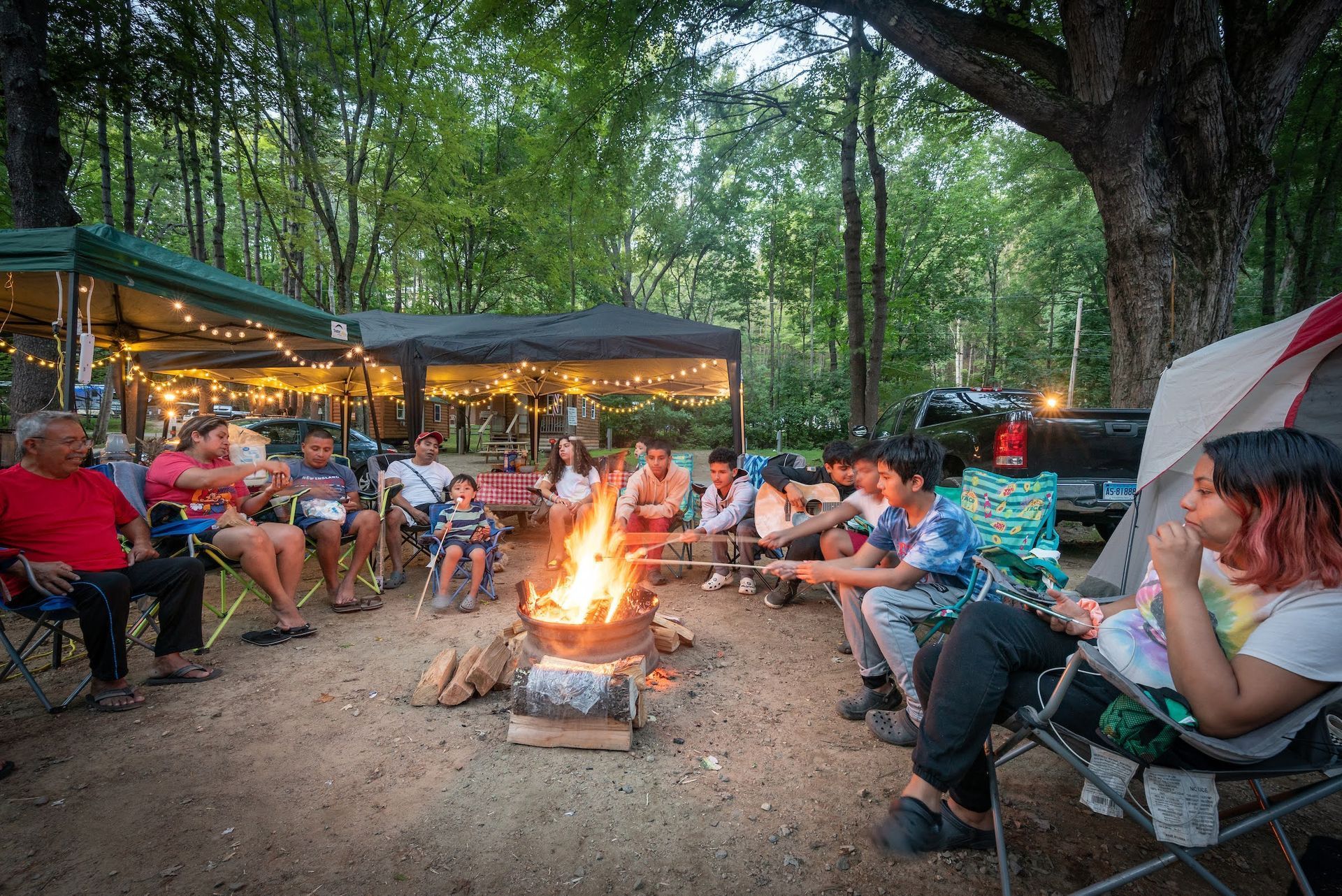 Group of People Are Sitting Around a Campfire