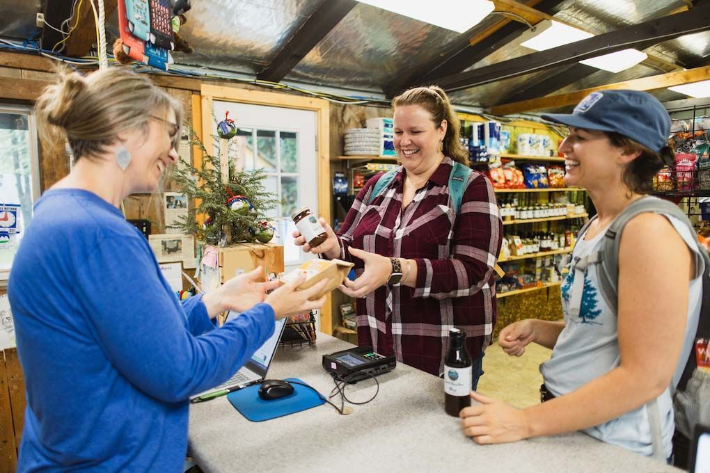 Three Women Are Standing at A Counter in A Store