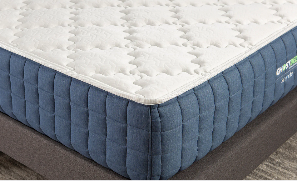 A blue and white mattress is sitting on top of a bed.