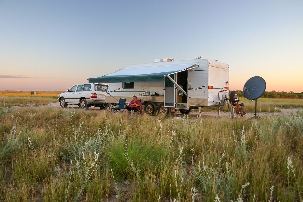 A RV is Parked in the Middle of a Grassy Field — Capital Caravans Pty Ltd In Woolgoolga, NSW