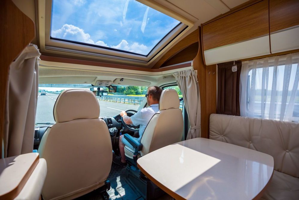 A Man is Driving a Camper Van on a Highway — Capital Caravans Pty Ltd In Raleigh, NSW