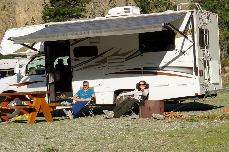 A Couple Sits in Front of a White RV — Capital Caravans Pty Ltd In Urunga, NSW