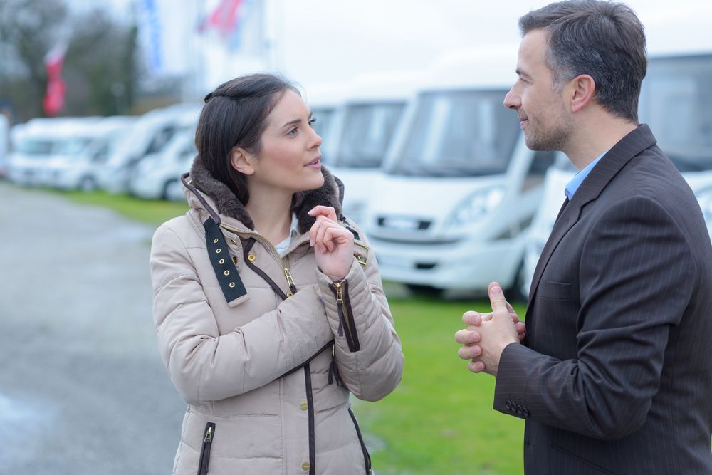 A Man and a Woman Are Talking in Front of a Row of Camper Vans — Capital Caravans Pty Ltd In Nambucca Heads, NSW