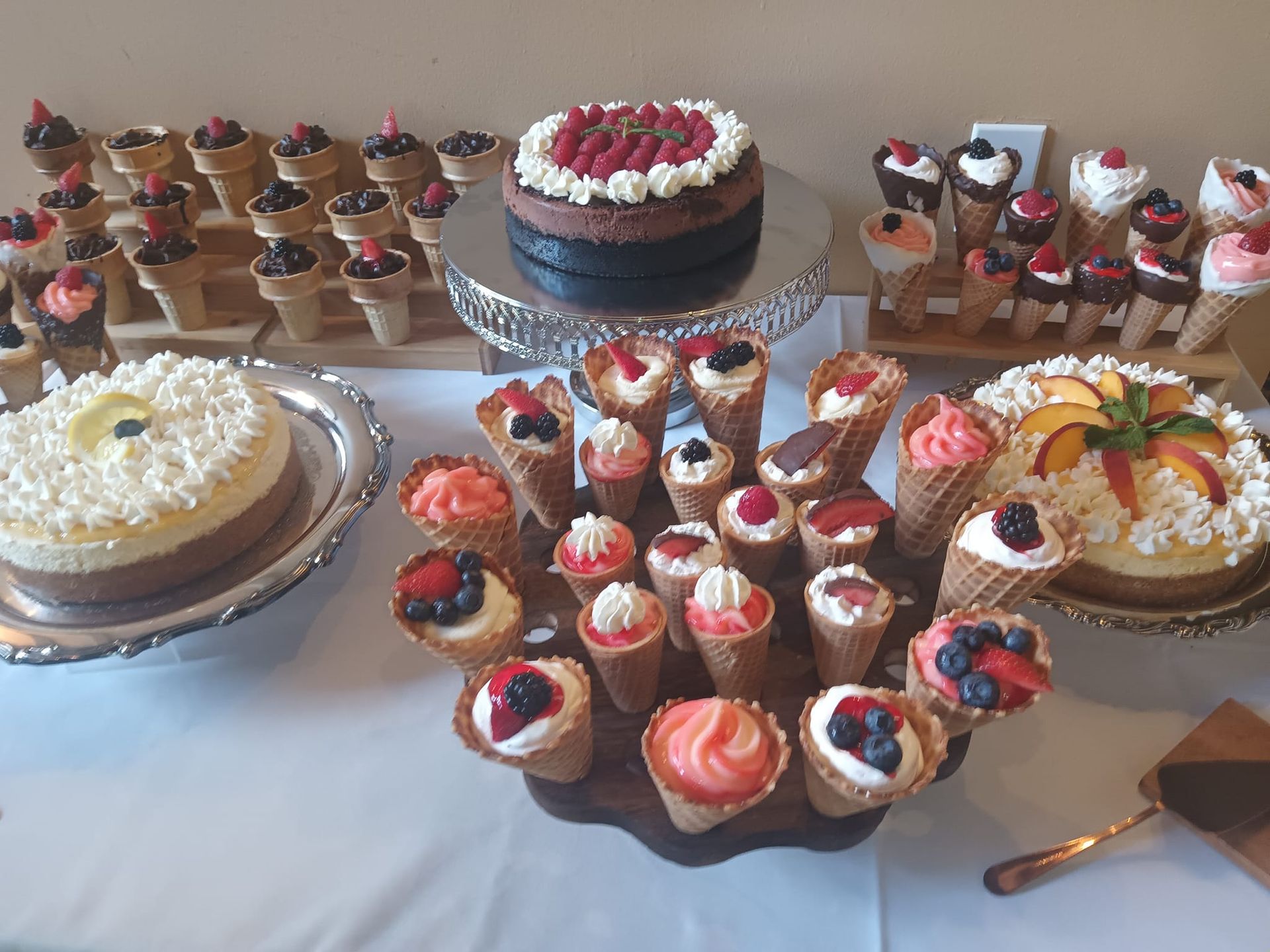 A table topped with a variety of desserts including cupcakes and cakes