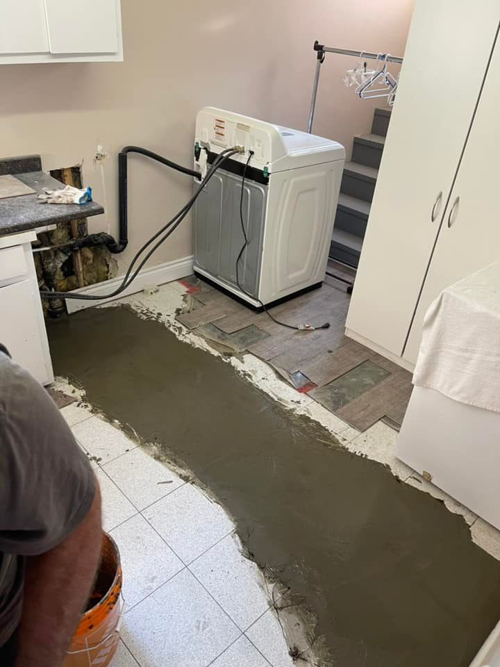 Buanderie avec machine à laver et une nouvelle dalle de béton en cours d'installation
