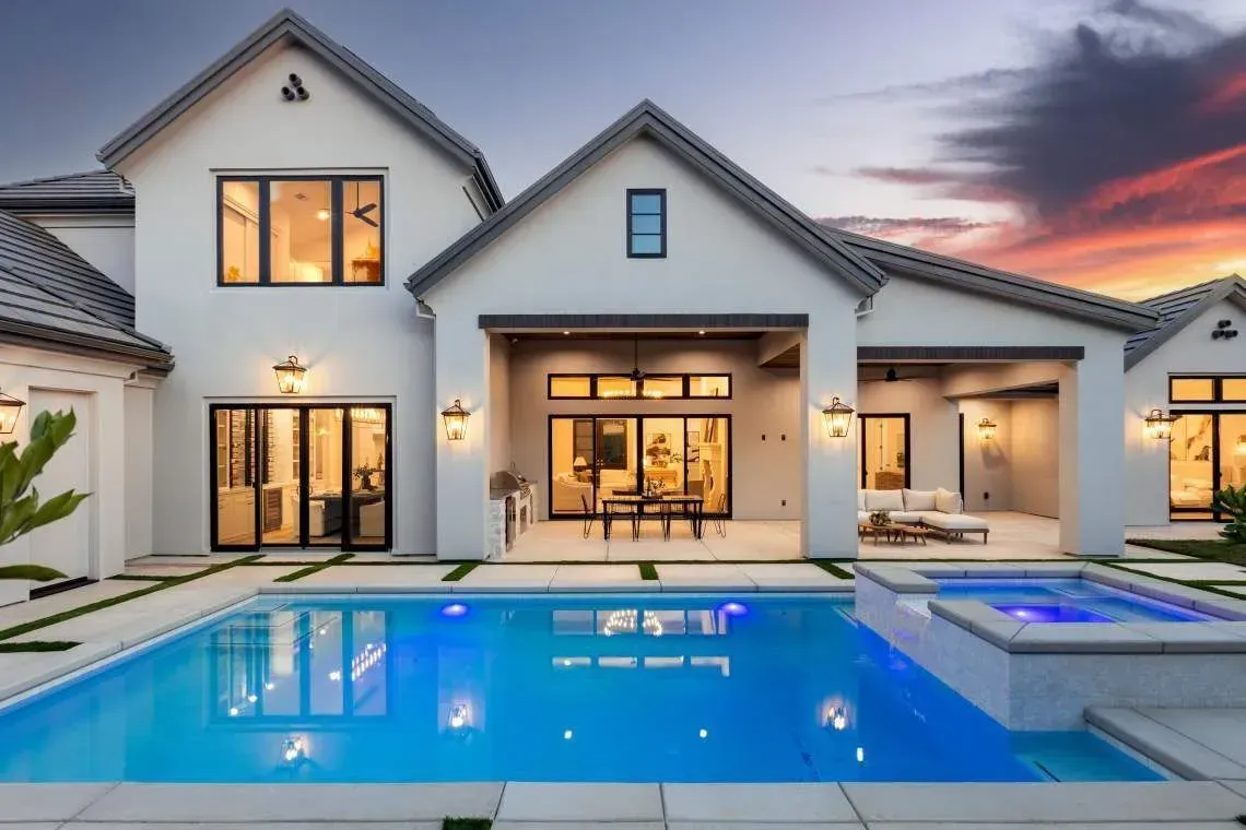 Modern luxury home at dusk with pool, outdoor lighting, and clean architectural lines.