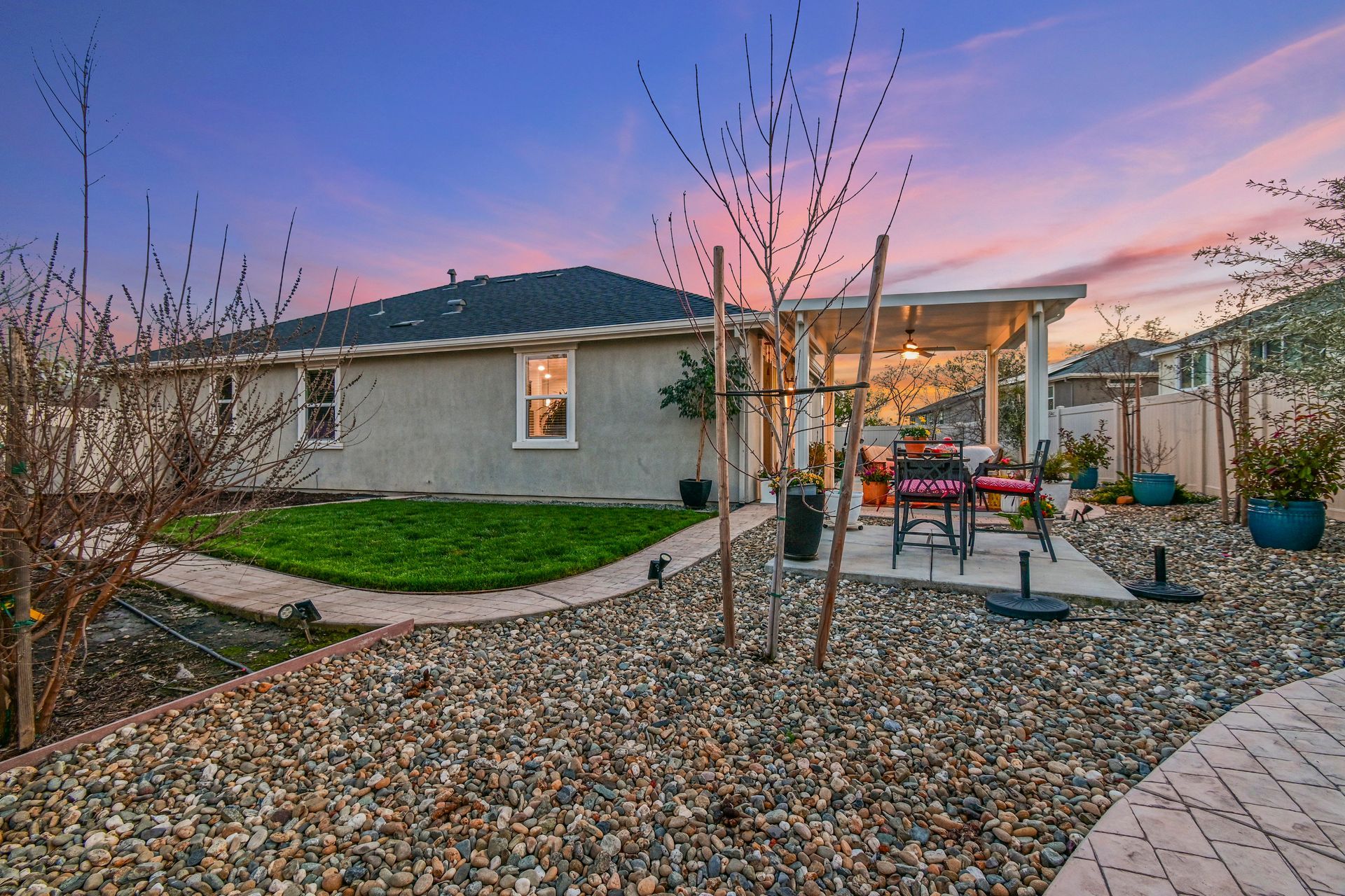 Covered patio with outdoor seating and potted plants, shown at twilight by a listing agent in Citrus Heights.