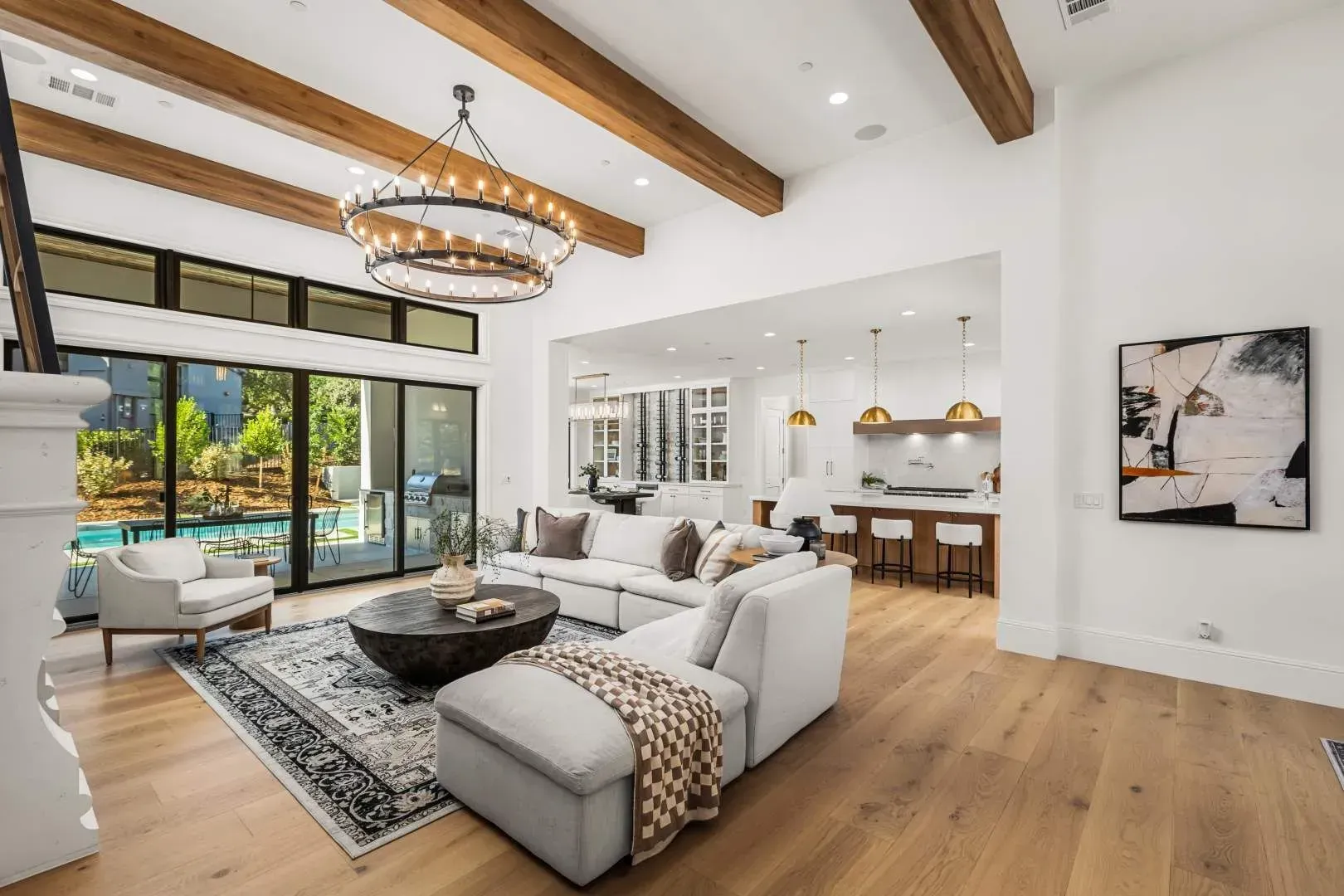 Spacious open-concept living area with wood-beamed ceilings and modern furniture.
