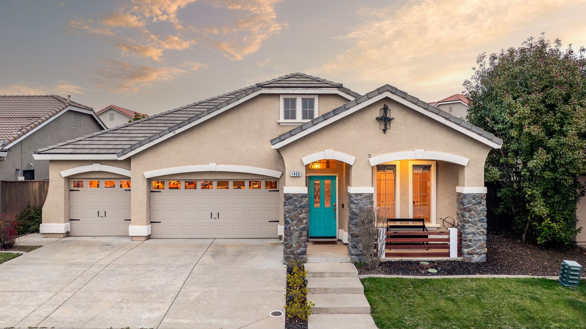 Luxury home for sale at La Guardia Circle featuring stone details, a vibrant front door, and a spacious three-car garage.