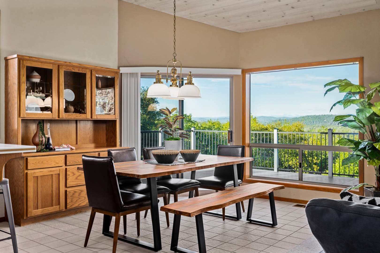 Dining room with wood cabinetry, scenic views, and natural light from large windows.