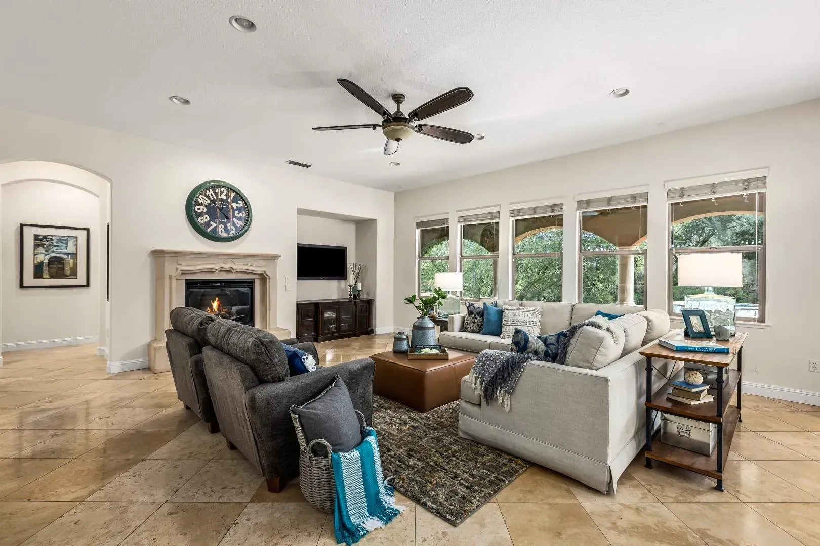 Bright living room with ceiling fan, neutral decor, and natural light.