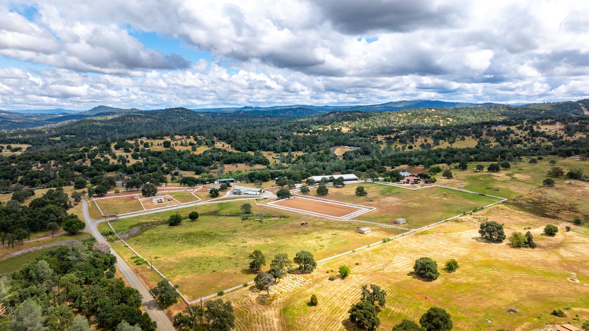 Aerial view of expansive horse property with riding arena and open pastures.