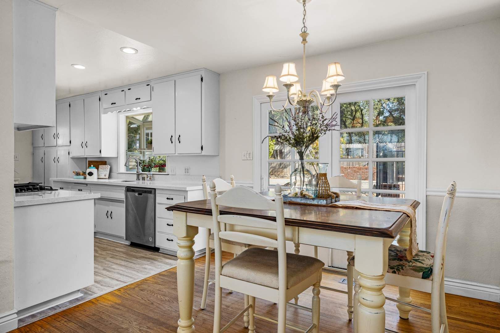 Bright and airy dining area with a classic chandelier in a well-staged home for sale.