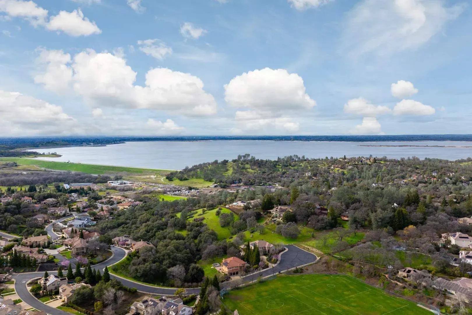 Aerial view of a waterfront landscape with open skies and sprawling country terrain.