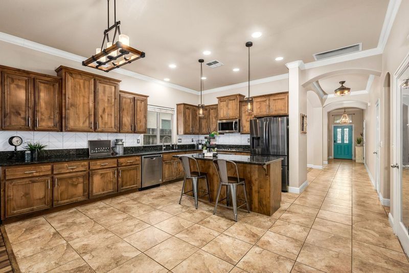 Modern kitchen on La Guardia Circle with wood cabinets, a large island, and stainless appliances.