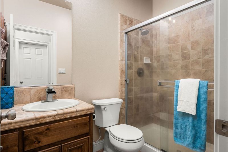 Bathroom on La Guardia Circle with shower, vanity, and modern tile flooring.