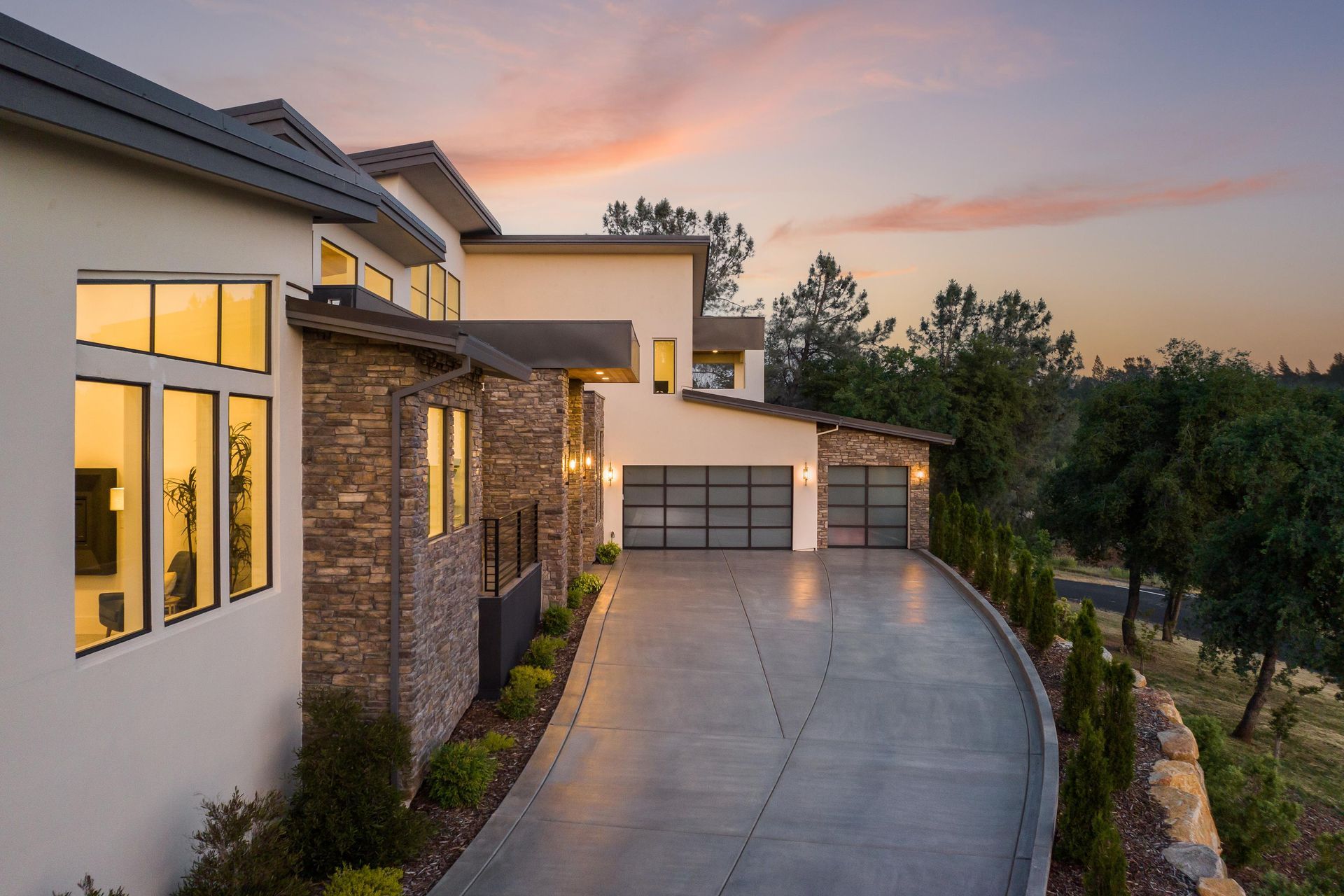 A large house with a concrete driveway leading to it | Homes for Sale
