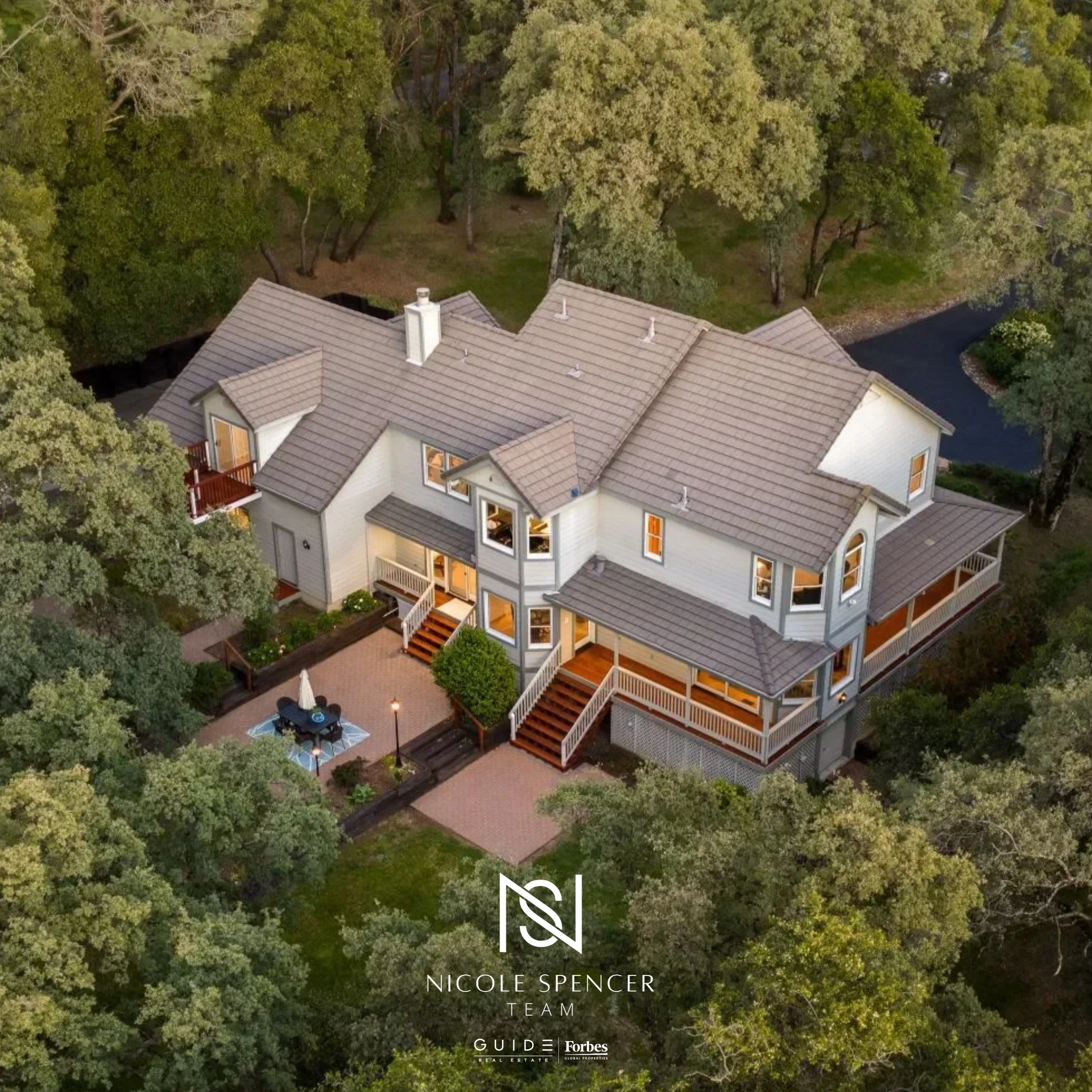 Aerial view of a property in Auburn, CA, set among lush greenery with Nicole Spencer - GUIDE Real Estate branding.
