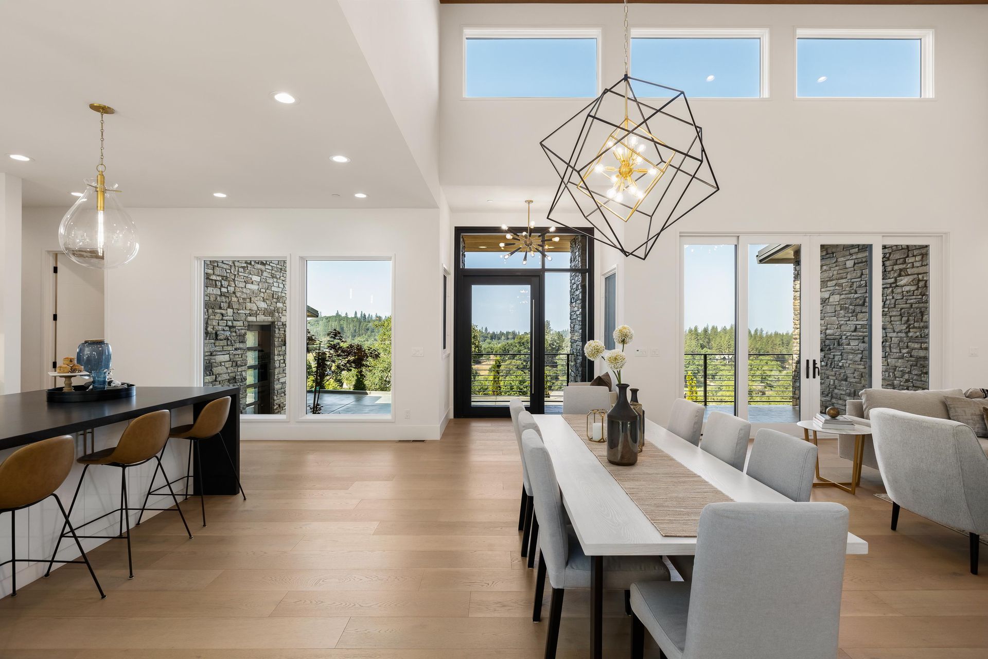 A dining room with a long table and chairs and a chandelier hanging from the ceiling | Luxury Homes