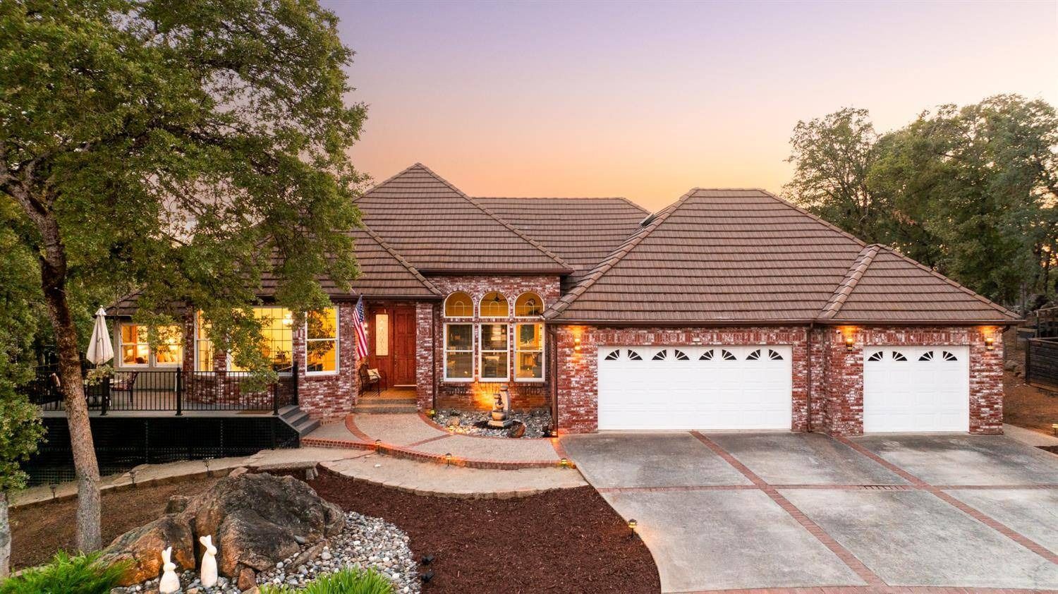  Beautiful brick home at sunset, showcasing curb appeal and luxury real estate design.
