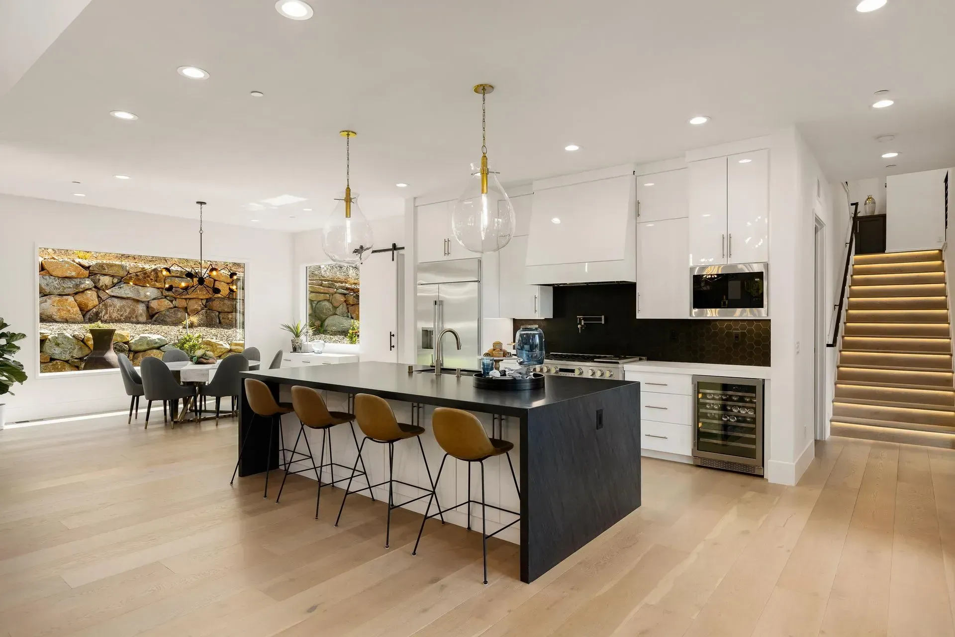 Open-concept kitchen with large island, dark cabinetry, and pendant lighting.