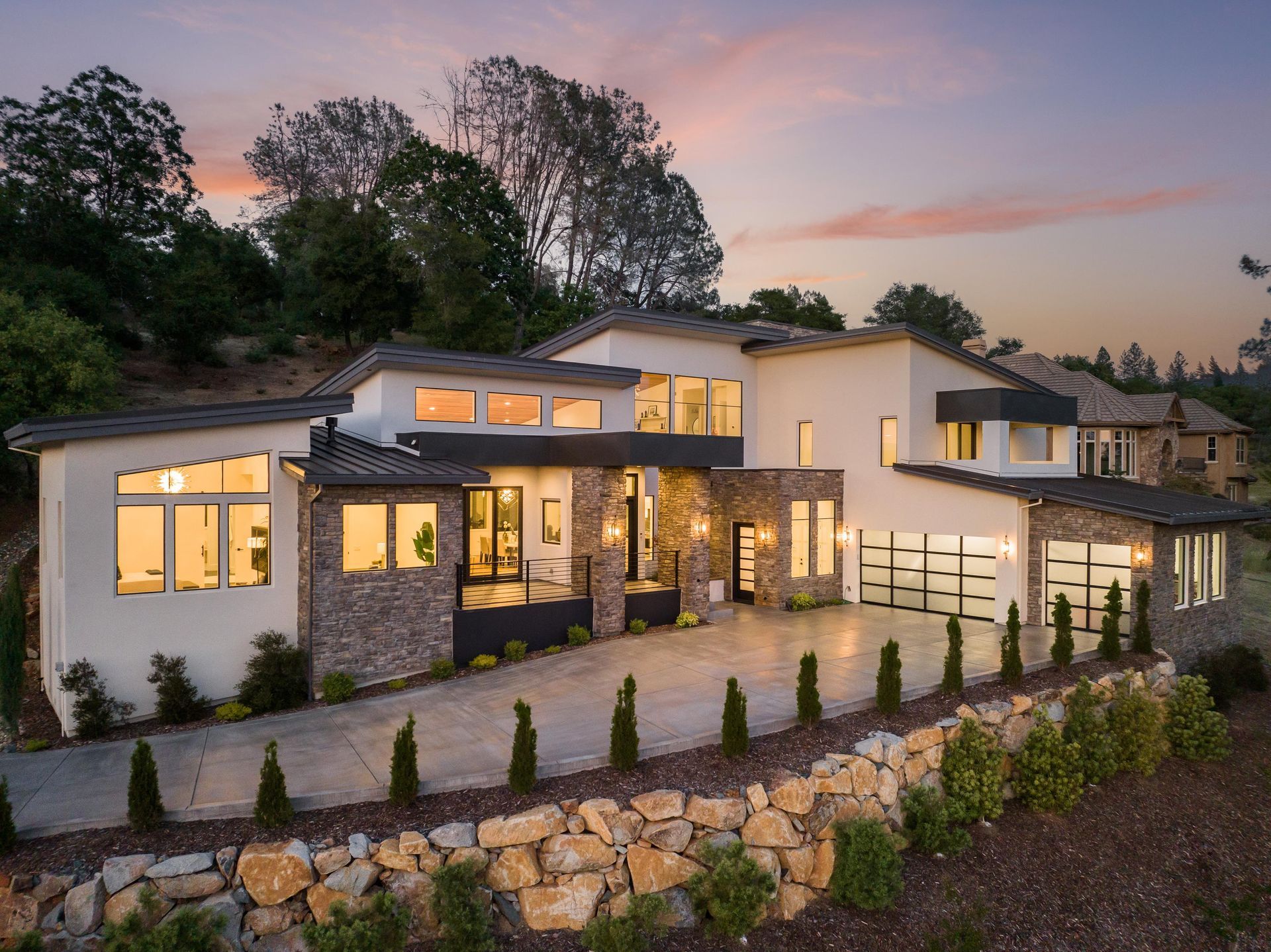 A large house with a lot of windows is sitting on top of a hill | Luxury Homes