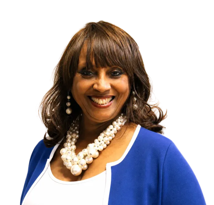 Debbie Meyers-Martin in blue blazer and white top, wearing layered pearl necklace