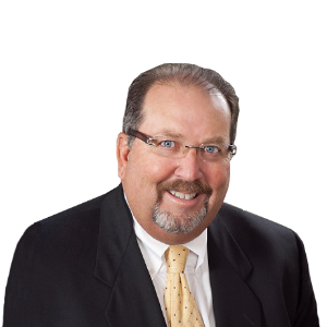 Smiling man in a dark suit, white shirt, and gold tie on a white background